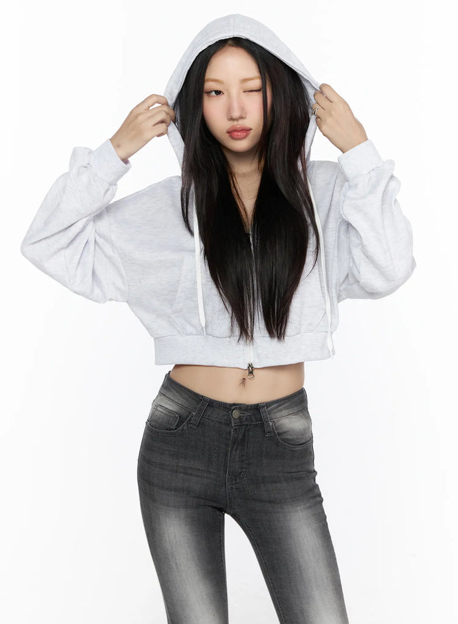 Zip-Up Crop Hoodie CL527 Light Gray front shot on model holding hood up with both hands paired with faded gray skinny jeans
