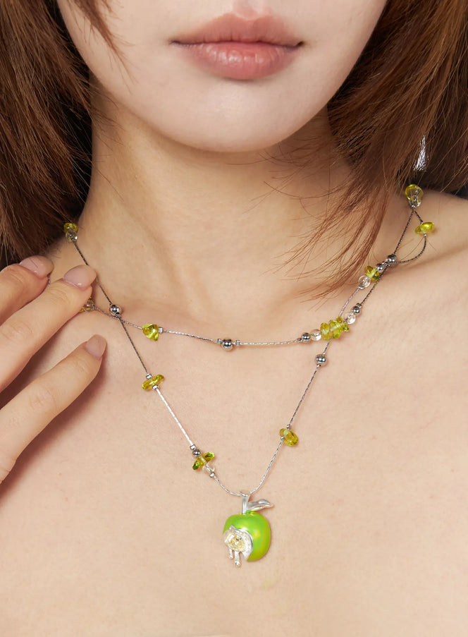 LEWKIN Corbusier Necklace IU503 in silver and green, worn on model, layered double-chain with green crystal beads and green apple pendant featuring crystal bite detail.