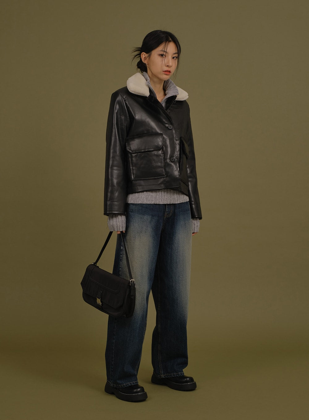 Washed Wide Denim Pants in blue, full-body side-angled shot on model, long wide leg with washed gradation, styled with black leather jacket and black shoulder bag.