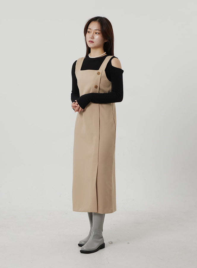 LEWKIN Wrapped Button Maxi Dress OF307 in beige, 3/4 front view on model, sleeveless square-neck silhouette with wrapped button placket, layered over black cold-shoulder top, styled with gray boots.