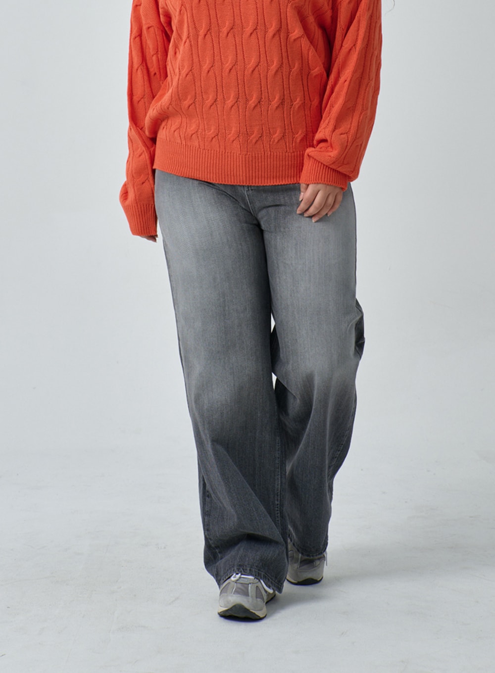 LEWKIN Plus Light Wash Wide Leg Jeans IF317 in grey wash, front waist-to-hem crop on plus-size model walking, wide cotton denim leg with faded wash, paired with orange cable-knit sweater and sneakers.