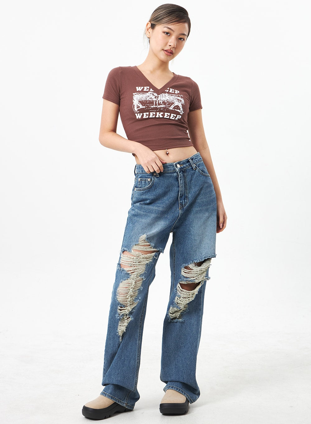 LEWKIN Wide Ripped Jeans CA304 in medium blue, full-body front on model, wide-leg cotton denim with heavy knee distressing and frayed threads, styled with brown crop tee and platform shoes.