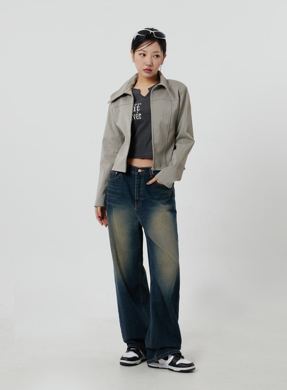 Dark Wash Jeans CF303 in blue, full-body front shot on model, deep indigo wide-leg denim with vintage yellow fading, styled with beige zip jacket and graphic crop top.