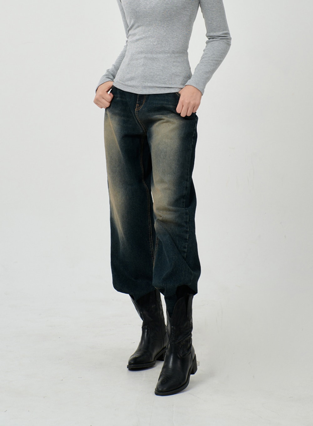 LEWKIN Vintage Washing Baggy Jeans ID23 in dark indigo, front close-up on model, wide-fit cotton denim with yellow-tinted wash, contrast stitching, paired with black knee-high boots.