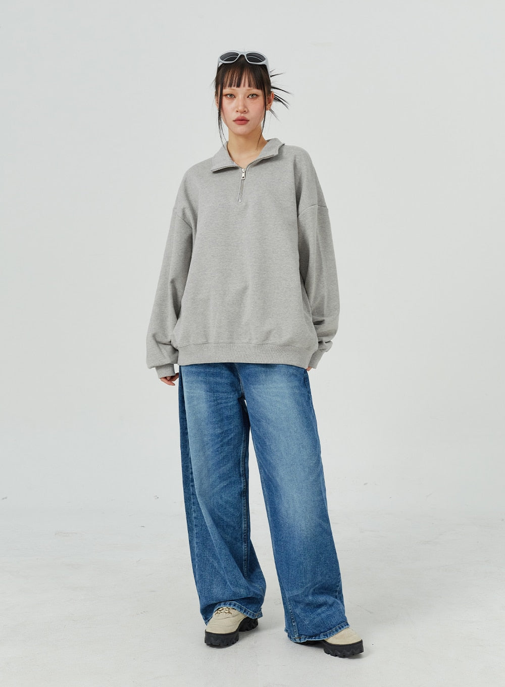 LEWKIN Oversized Jeans Unisex CM321 in blue, full-length front on model, wide-leg cotton denim with faded wash, paired with grey half-zip sweatshirt and chunky sneakers.