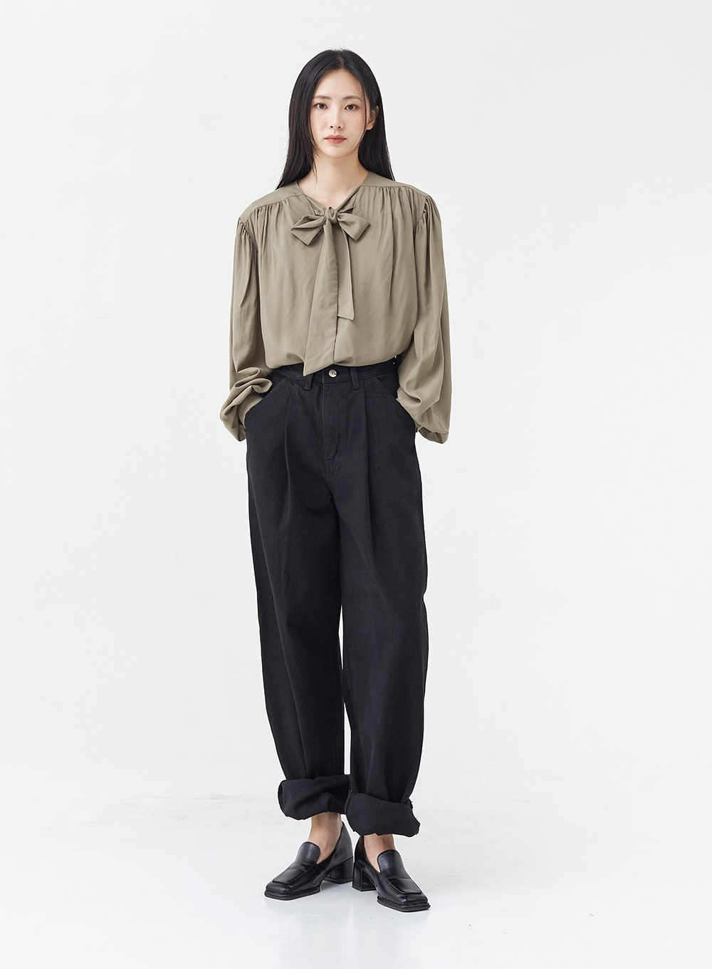 LEWKIN Pintuck Black Jeans OG18 in black, full-body front shot on model, wide-fit cotton with pintuck detail and rolled cuffs, styled with olive bow blouse and black loafers.