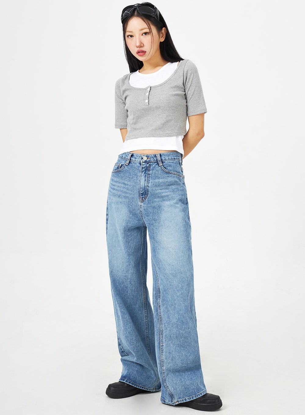 LEWKIN Mid-Wash Bootcut Jeans CM323 in mid blue, full-length front view on model, wide-fit washed cotton denim with high waist, paired with grey crop top and black chunky shoes.