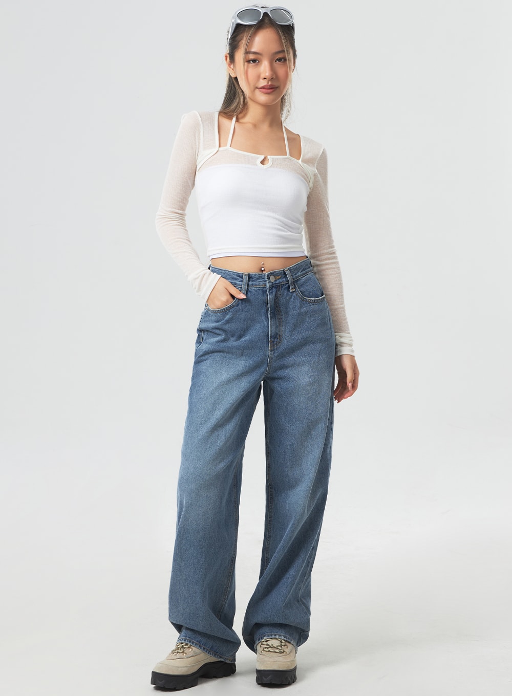 LEWKIN Wide Leg Mid-Wash Jeans CM331 in mid-wash blue, full-length front view on model, wide-fit cotton denim, high-rise waist, paired with white mesh crop top and chunky sneakers.