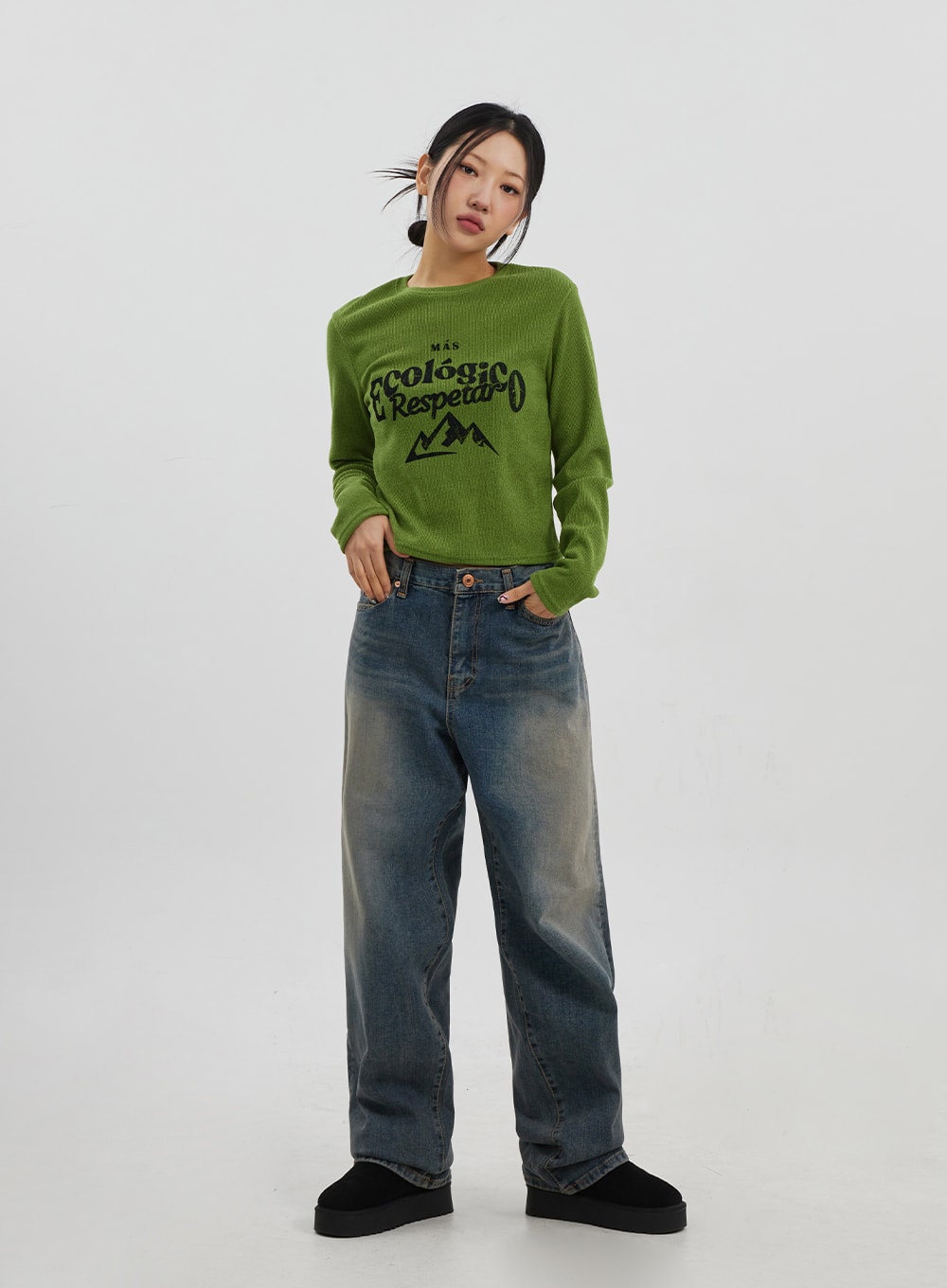 LEWKIN Mid-Rise Baggy Jeans Unisex CJ330 in vintage blue, full-body front view on model, wide-fit cotton denim with faded wash, styled with green graphic knit top and black platform shoes.