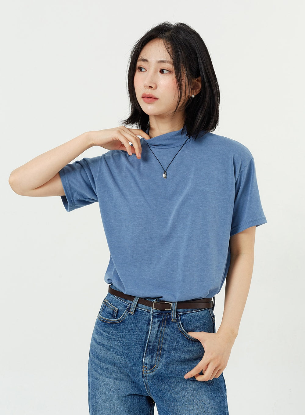 Side Slit Jeans OM308 in mid blue, upper waistband close-up on model, high-rise cotton denim with belt loops and brown leather belt, feminine wide-fit silhouette.