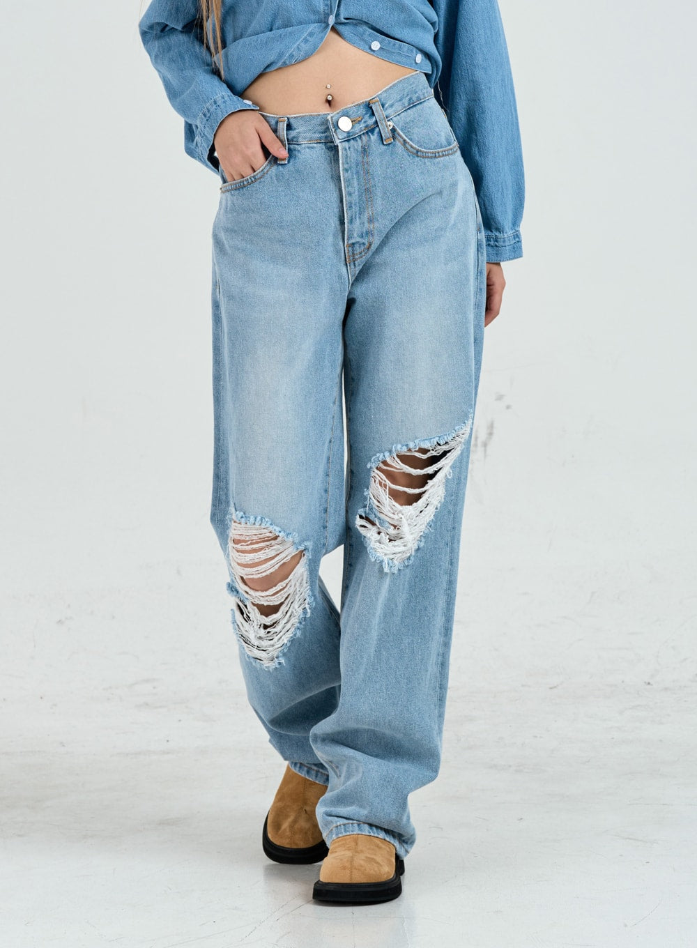 LEWKIN Ripped Maxi Denim Pants Unisex CO14 in light blue, front close-up on model, wide-fit cotton denim with large destroyed knee rips, paired with denim shirt.