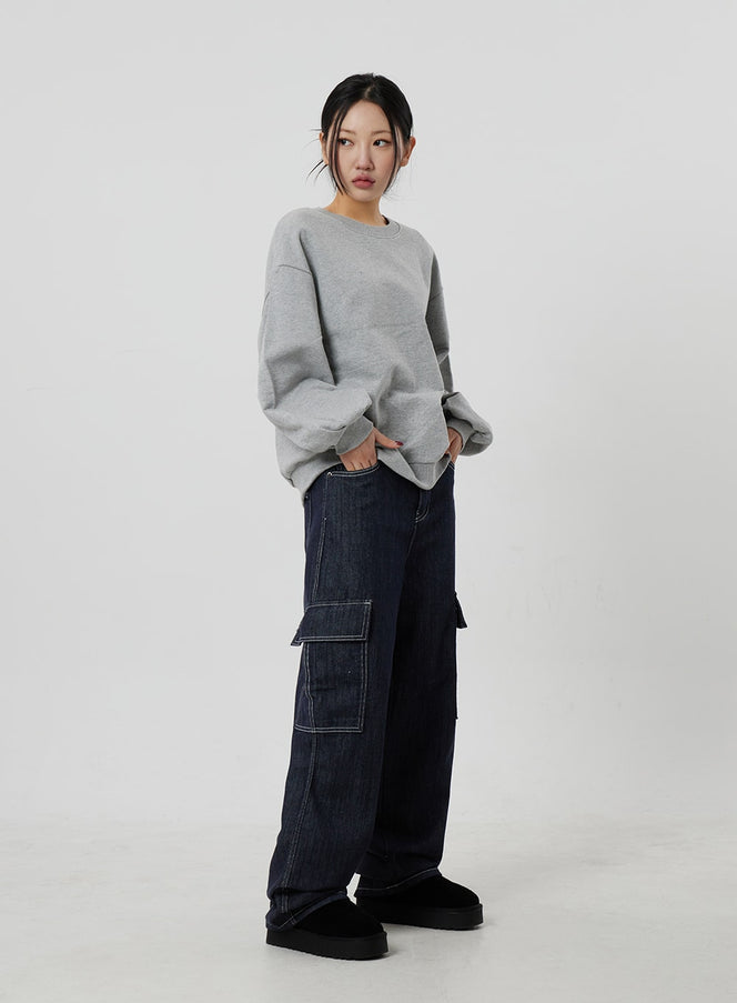 LEWKIN Wide Cargo Jeans CF302 in dark indigo, full-length front-angle on model, wide-fit cotton denim with contrast white stitch cargo pockets, styled with grey sweatshirt and black platform shoes.