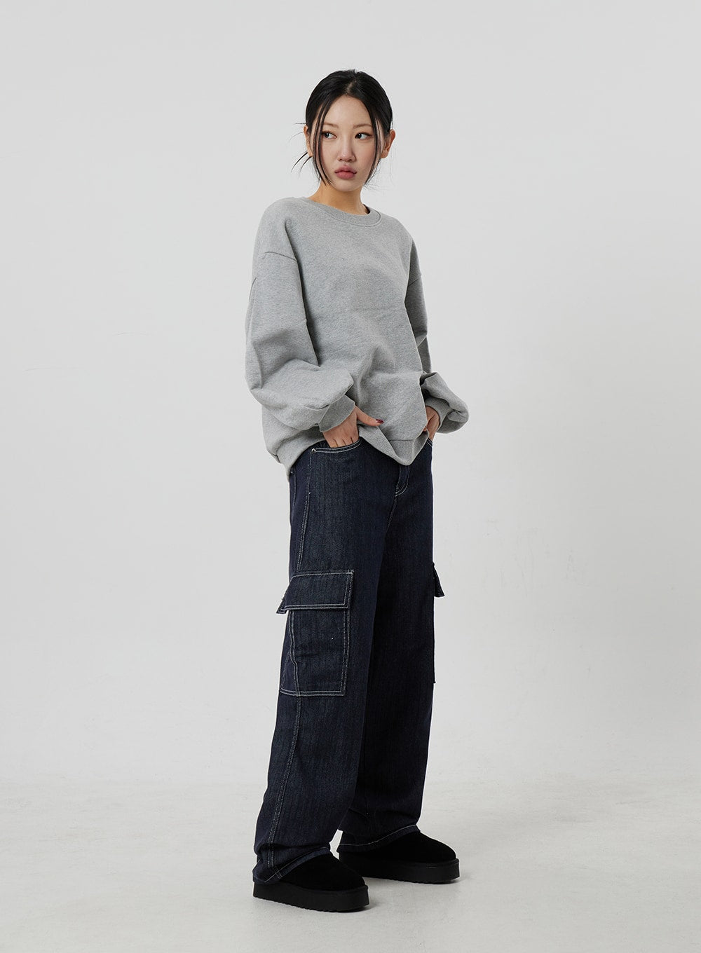 LEWKIN Wide Cargo Jeans CF302 in dark indigo, full-length front-angle on model, wide-fit cotton denim with contrast white stitch cargo pockets, styled with grey sweatshirt and black platform shoes.