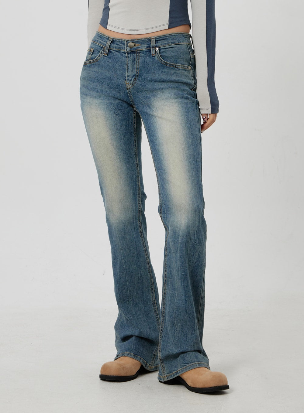 Low Rise Bootcut Jeans CF302 in blue, cropped front close-up on model, low waist with five-pocket design, vintage wash fading, slim bootcut leg, paired with blue long-sleeve top.
