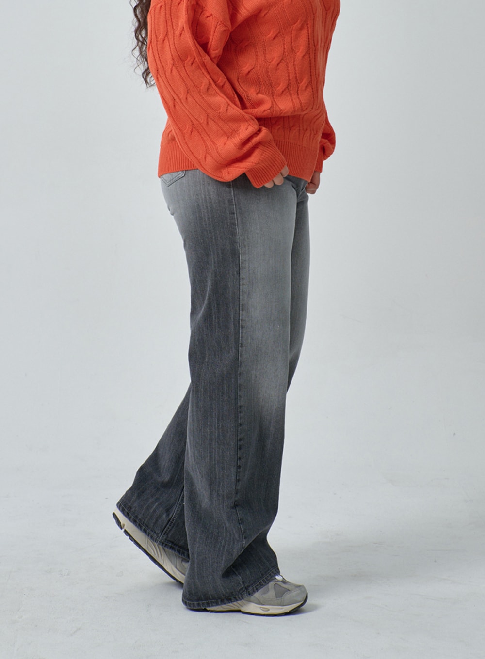 Plus Light Wash Wide Leg Jeans IF317 in grey wash, side view on plus-size model, full-length wide leg silhouette with faded denim, paired with orange cable-knit sweater and grey sneakers.