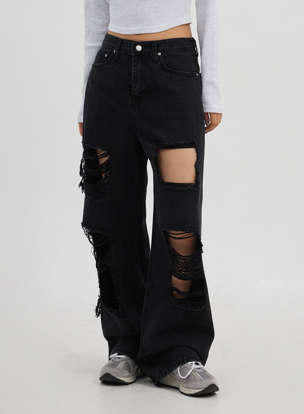 Ripped Wide Leg Jeans CJ319 in black, front mid-body close-up on model, large frayed rip openings at thigh and knee, wide-leg silhouette pooling at sneakers.
