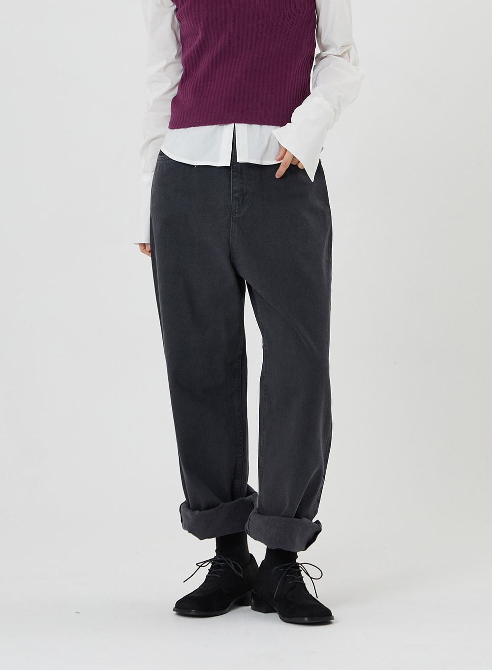 LEWKIN Maxi Denim Pants ON23 in charcoal grey, cropped front view on model, wide-fit cotton denim with rolled cuffs, paired with white shirt and purple knit vest, black oxford shoes.
