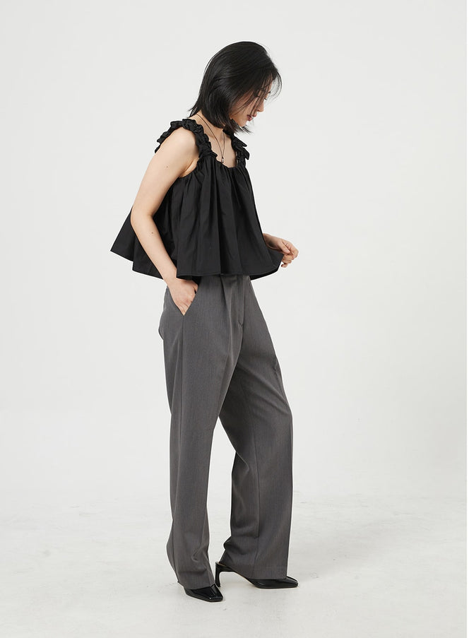 Basic Tailored Pants OM328 in dark gray, side view on model, wide-fit pintuck tailored trousers showing straight leg silhouette, styled with black camisole and black heels.