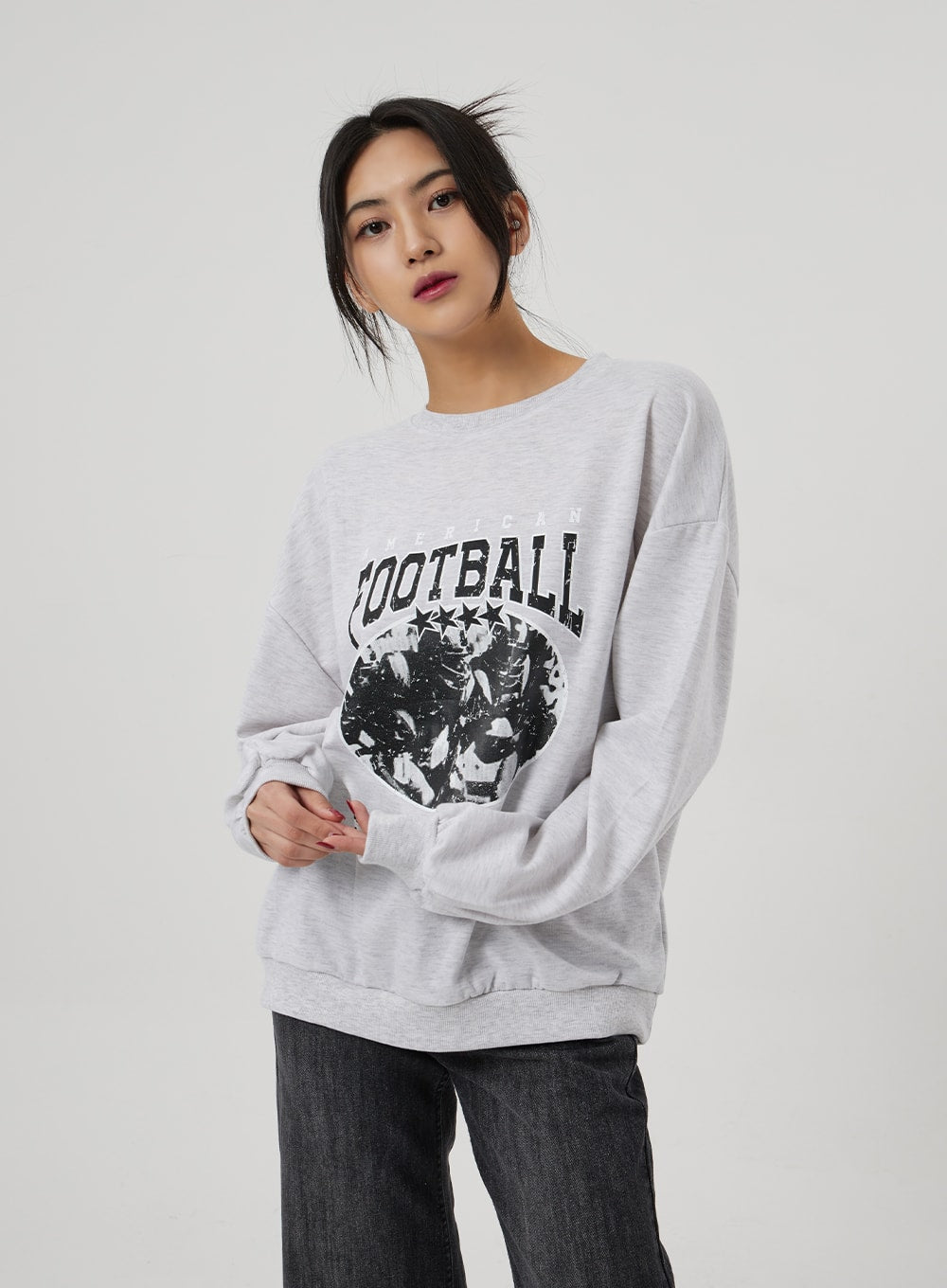 Wide Straight Leg Jeans BF310 in washed black, upper-body and waist crop on model, high-rise wide-fit denim visible at hem, paired with heather grey football graphic sweatshirt.