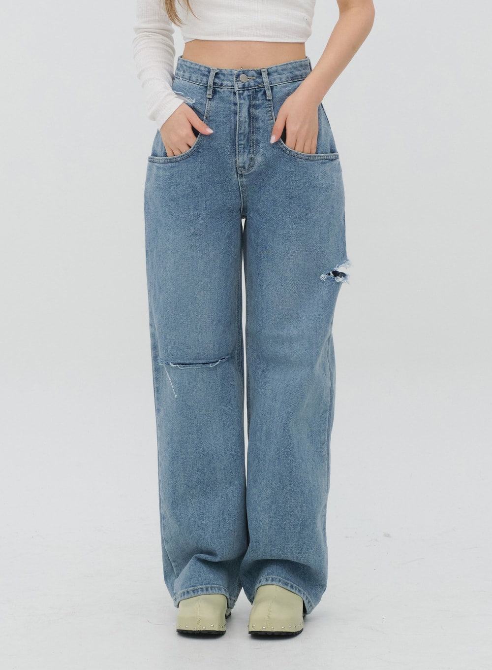 Torn Wide Leg Jeans C1002 in light blue, front waist-to-hem close-up on model, high-rise cut with destroyed knee cutouts and slash detail, paired with white crop top.