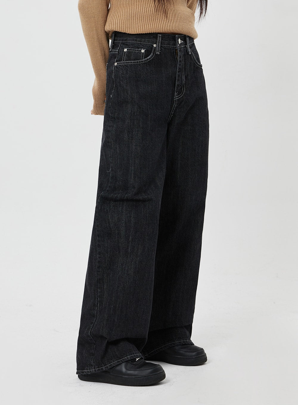Straight Leg Jeans CF315 in black, side close-up on model, wide-fit straight denim with high waist and contrast topstitching, styled with camel knit top.