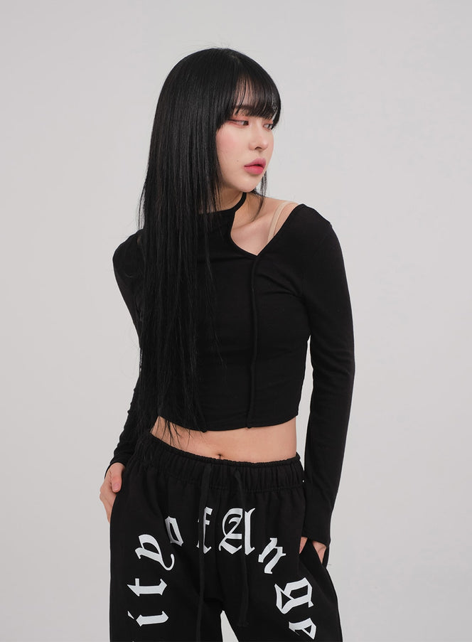 Cut Out Long Sleeve Top C0302 in black, side-front close-up on model, halter-neck choker band and asymmetric cut-out neckline visible, slim crop silhouette, with graphic sweatpants.