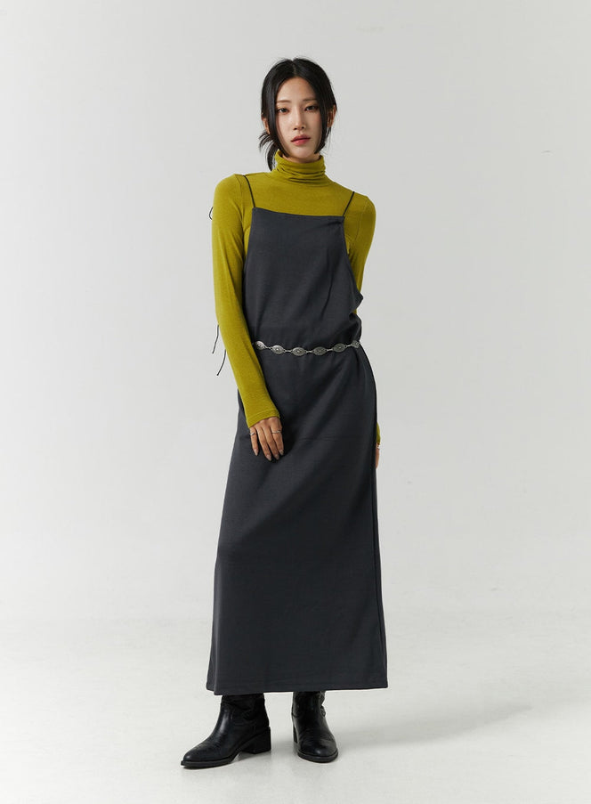 Open Back Strap Sleeveless Maxi Dress CN328 in dark gray, front full-body on model, straight silhouette, paired with olive turtleneck, chain belt, and ankle boots.