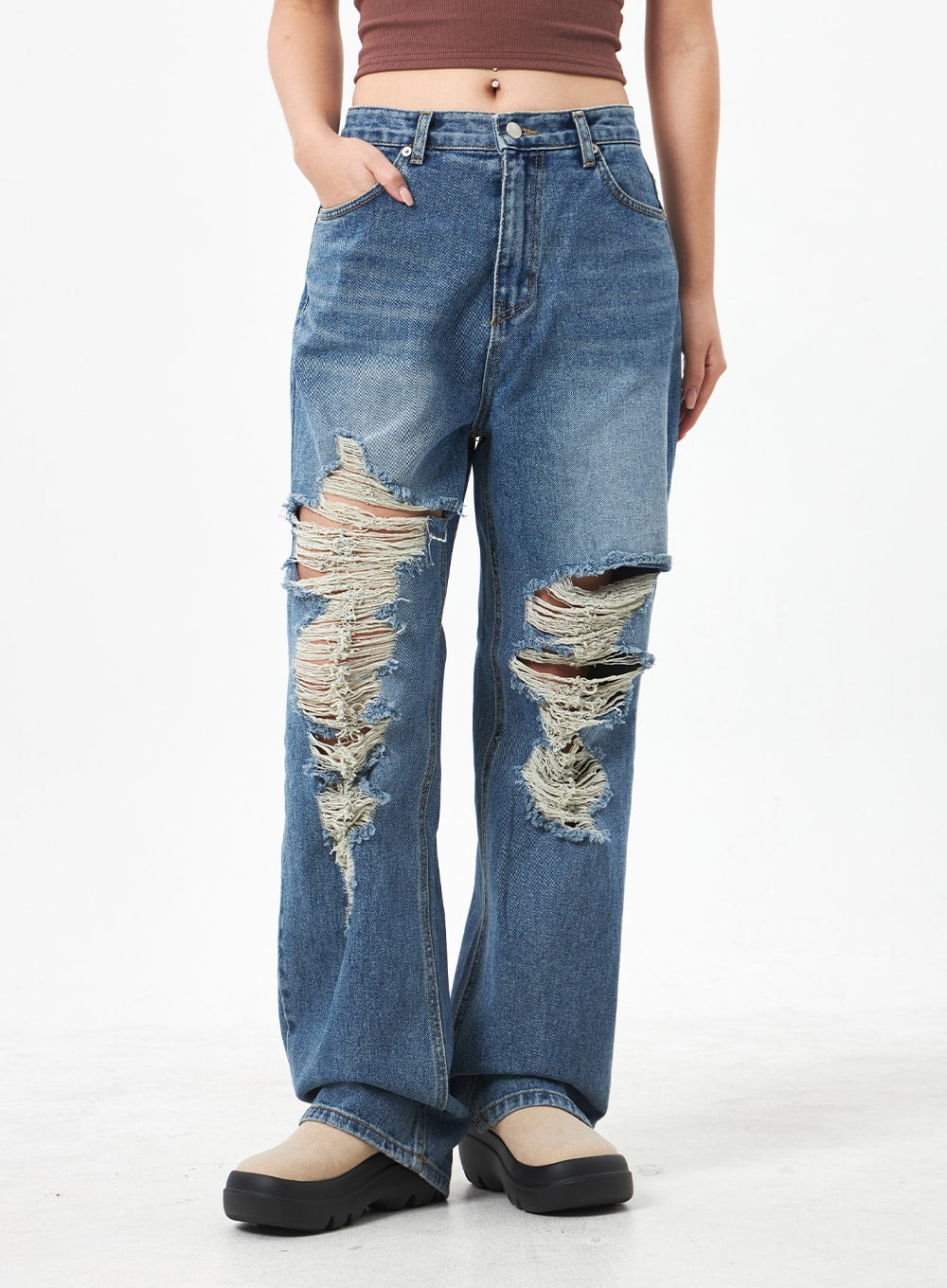 Wide Ripped Jeans CA304 in medium blue, front mid-body close-up on model, wide-leg denim with large ripped knee cutouts and raw frayed edges, five-pocket styling visible.