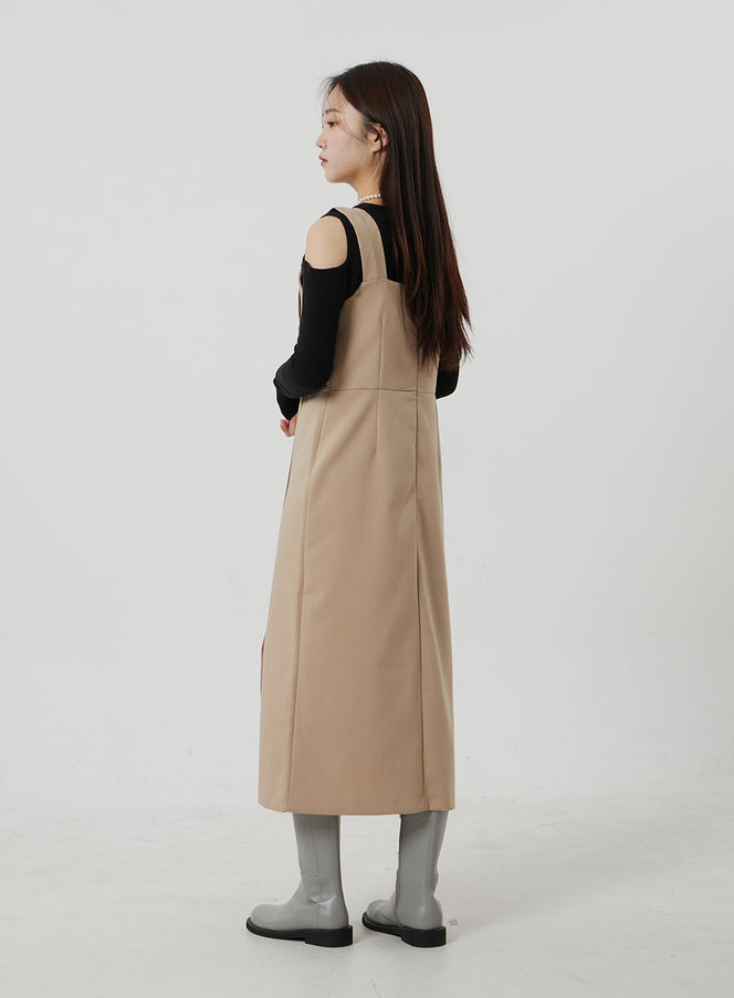 Wrapped Button Maxi Dress OF307 in beige, back side view on model, showing smooth polyester finish and side seam detail, layered over black long-sleeve top, paired with gray boots.