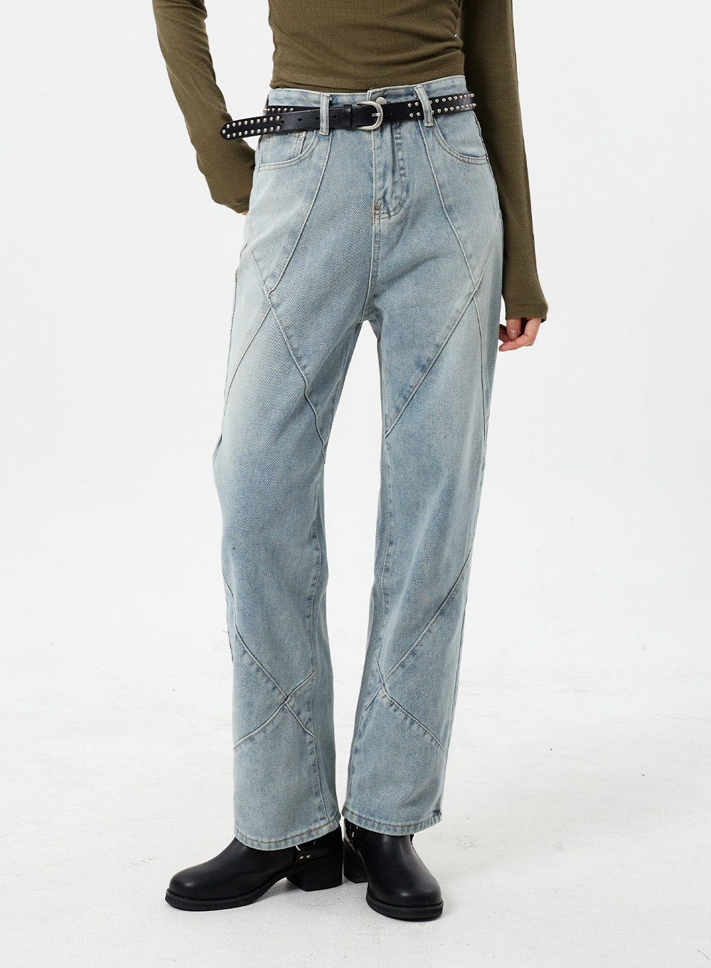 Light Wash Straight Leg Jeans CM307 in light blue, front mid-shot on model, straight fit with bold diagonal patchwork seams, high waist, paired with olive top and studded belt.
