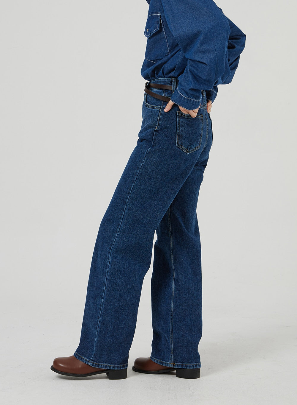 Basic Indigo Jeans OF310 in indigo, side close-up from waist to hem on model, wide-leg cut with rear pocket detail and brown leather belt, paired with denim shirt and brown boots.