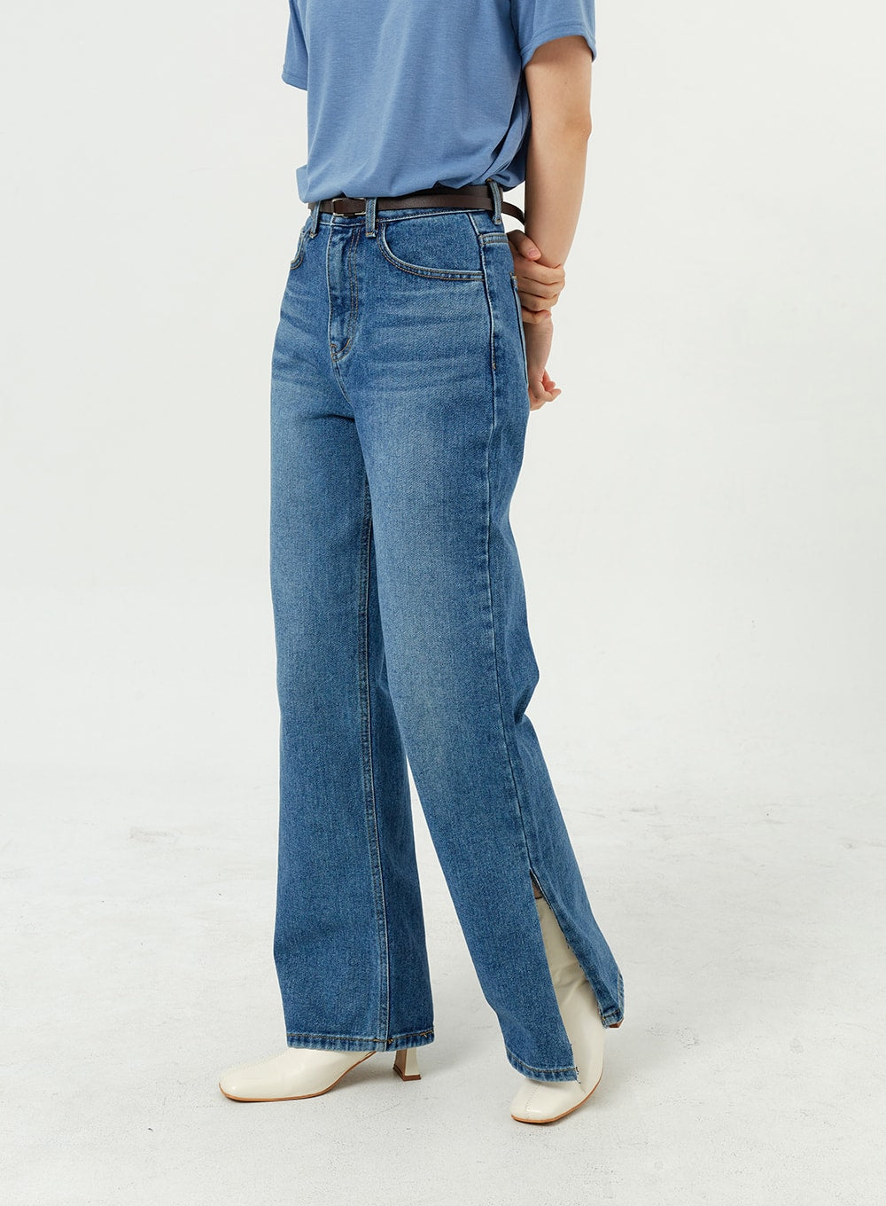 Side Slit Jeans OM308 in mid blue, front close-up from waist to hem on model, high-rise wide-leg cotton denim with visible side slit at ankle, belted waist.