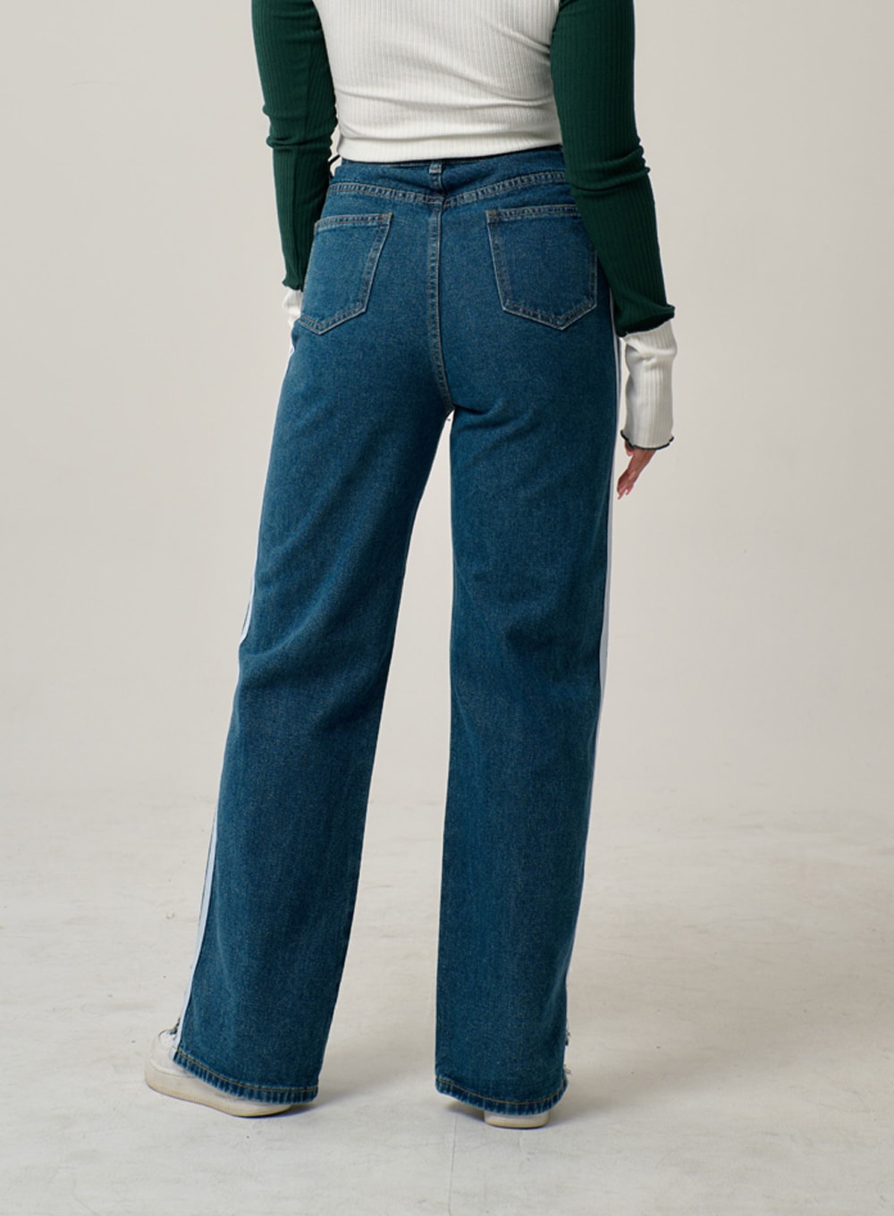 Side Stripes Straight Leg Jeans IN22 in mid blue, back view on model, high-rise wide-fit denim with dual back pockets and white side stripes visible at edges, paired with ribbed crop top.