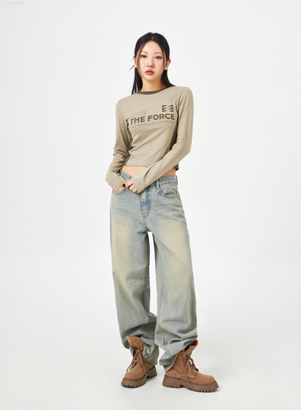 Light Blue Baggy Jeans CM323 in light blue, full-body front shot on model standing straight, relaxed wide-fit washed denim, styled with khaki graphic crop top and boots.