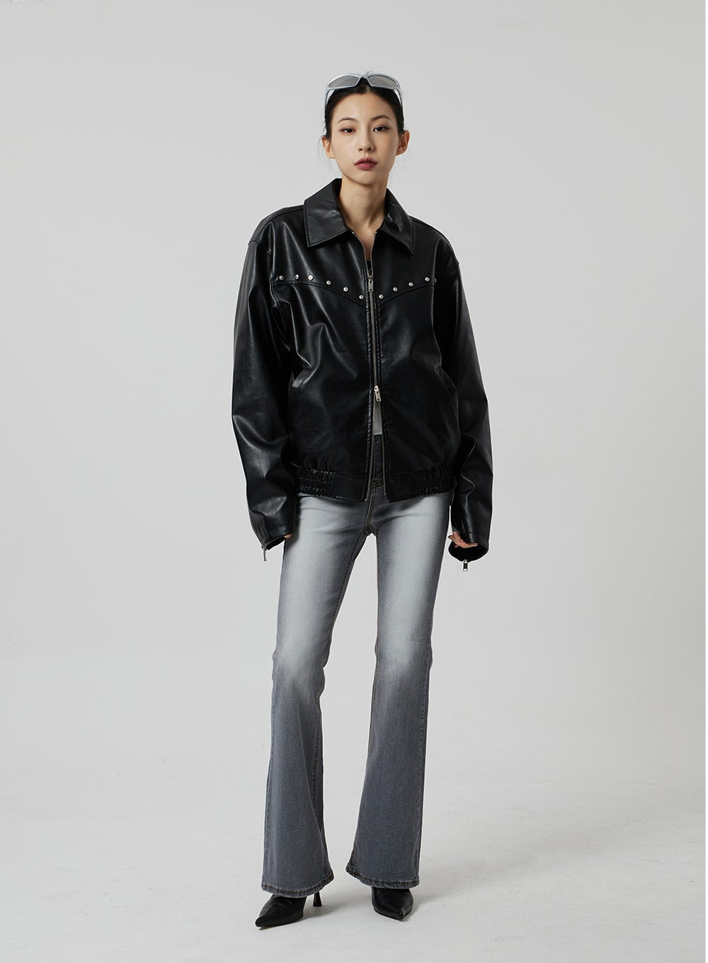 Slim Fit Bootcut Jeans CF307 in grey, full-length front view on model, slim fit through thigh flaring at hem, worn with oversized black faux-leather jacket, hands in pockets.