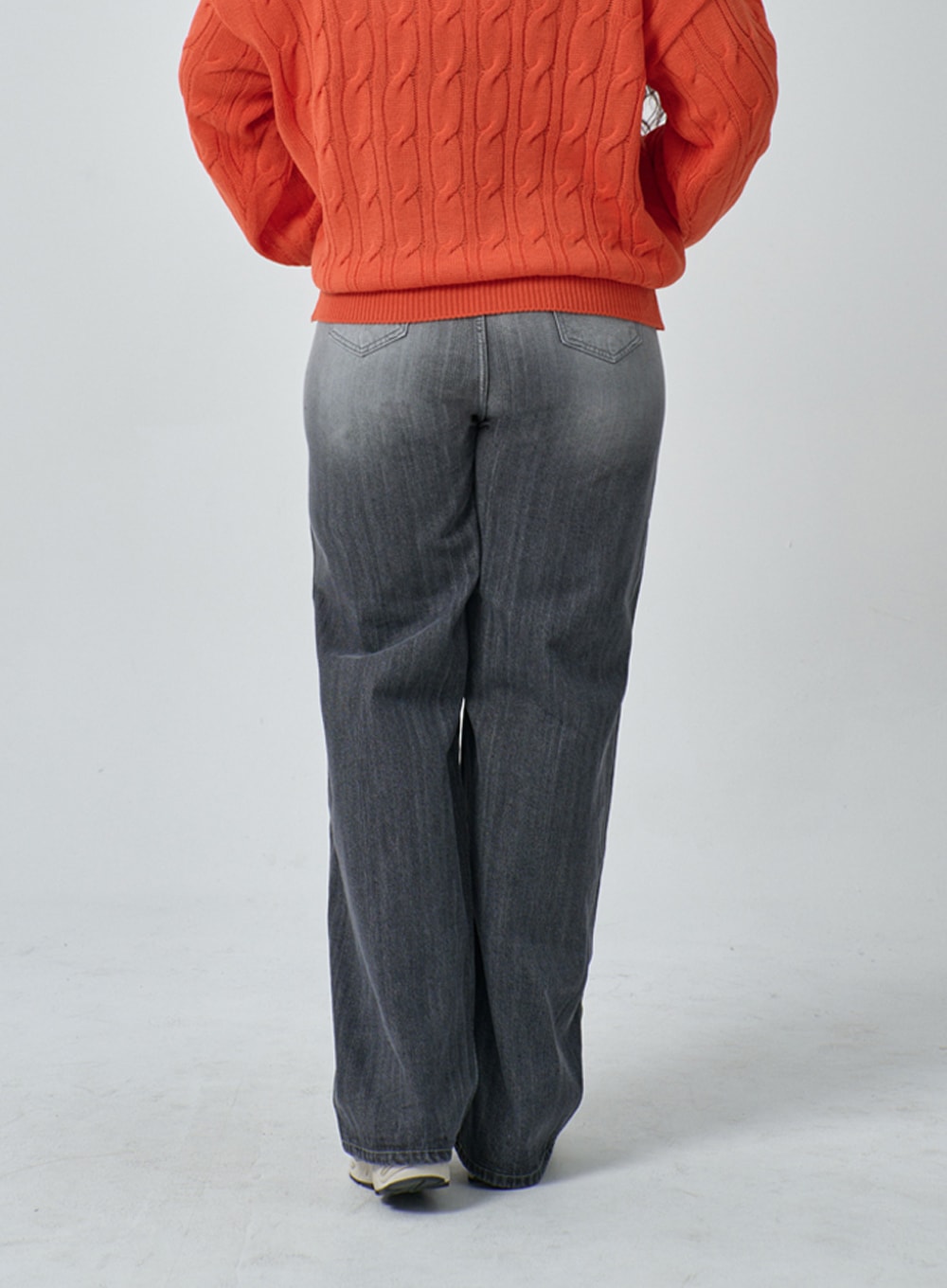 Plus Light Wash Wide Leg Jeans IF317 in grey wash, back view on plus-size model, wide leg cotton denim with back pocket stitching and gradient fade, paired with orange cable-knit sweater.