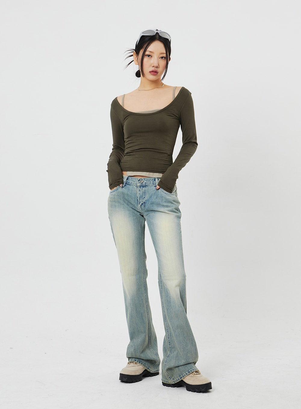 Low Rise Bootcut Jeans CF315 in light blue, front full-length shot on model facing camera, slim low-rise fit with yellow-tinted fade, styled with olive long-sleeve crop top.