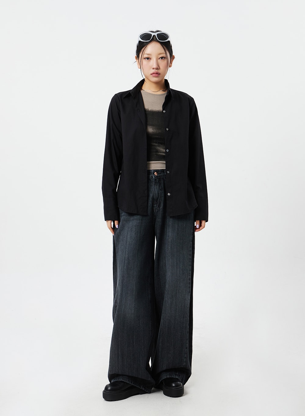 Mid-Rise Baggy Jeans CM324 in washed black denim, full-body front shot on model standing straight, floor-grazing wide leg, paired with black button-up shirt and beige layering top.