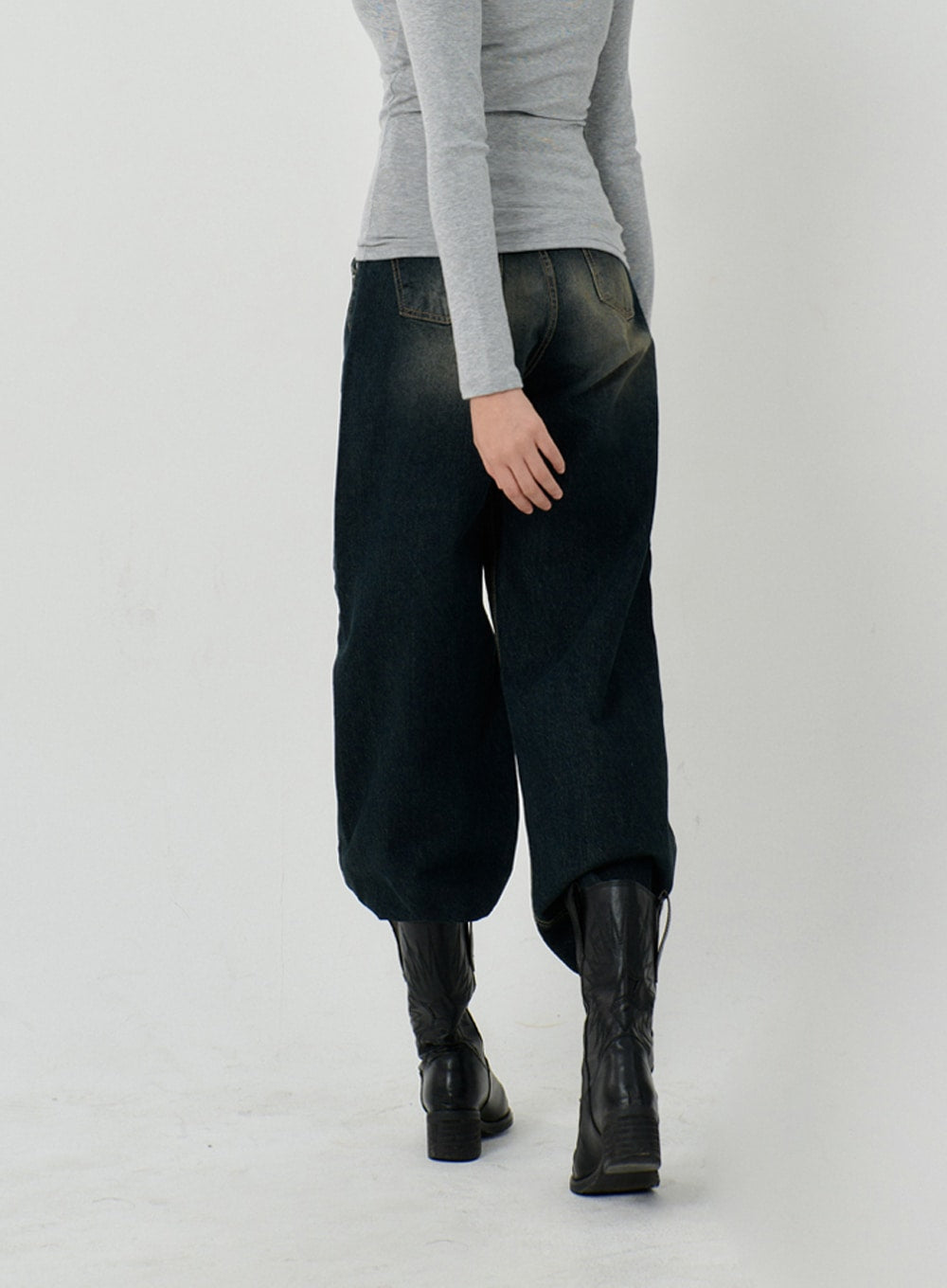 Vintage Washing Baggy Jeans ID23 in dark indigo, back view on model, wide baggy leg with contrast stitching and vintage washed finish, worn with grey top and black knee-high boots.