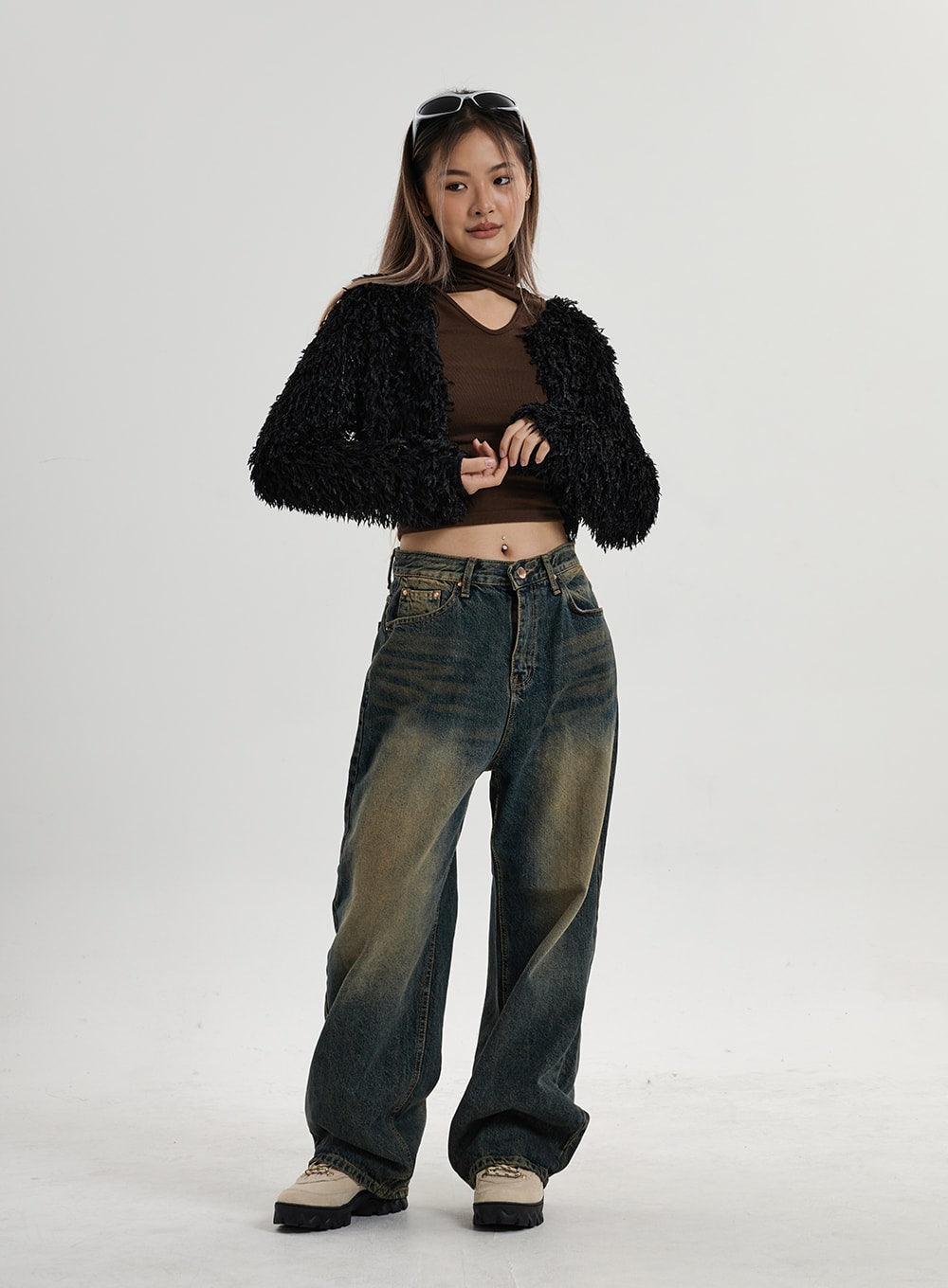 Vintage Washing Wide Leg Denim Pants CN14 in vintage washed indigo, full-body slight angle on model, relaxed wide-fit denim with dusty yellow fade, styled with black fluffy cardigan and brown crop top.