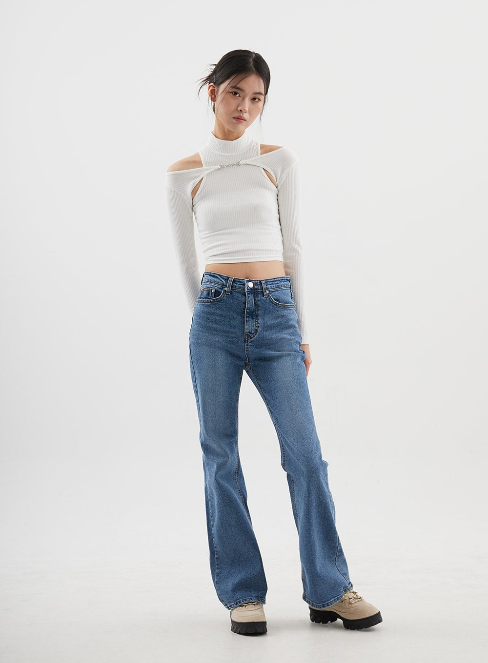 Slim Fit Bootcut Jeans CJ311 in medium blue, three-quarter front angle on model, slim thigh tapering into bootcut hem, styled with white cut-out turtleneck crop top.