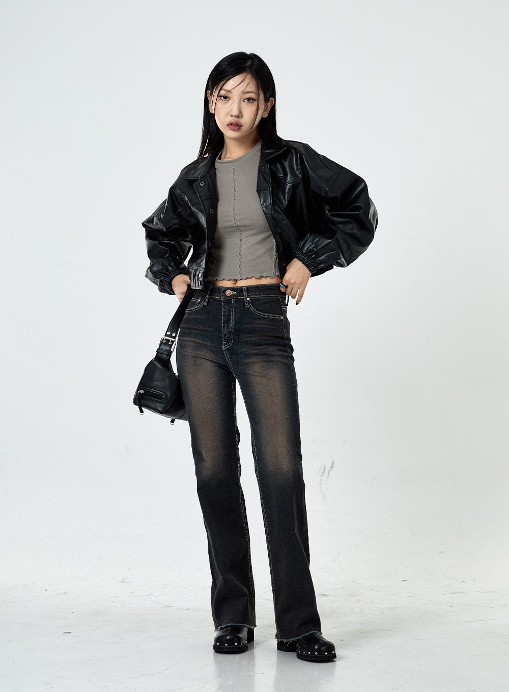 Basic Washed Bootcut Jeans CS07 in black washed denim, full-length front view on model with hands on hips, slim bootcut silhouette, styled with black crop leather jacket and mini bag.