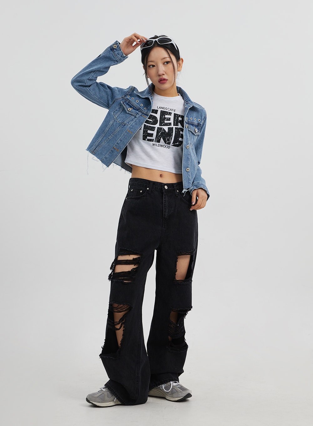 Ripped Wide Leg Jeans CJ319 in black, full-length front on model with dynamic pose, multi-rip destroyed denim, paired with cropped blue denim jacket and white graphic tee.