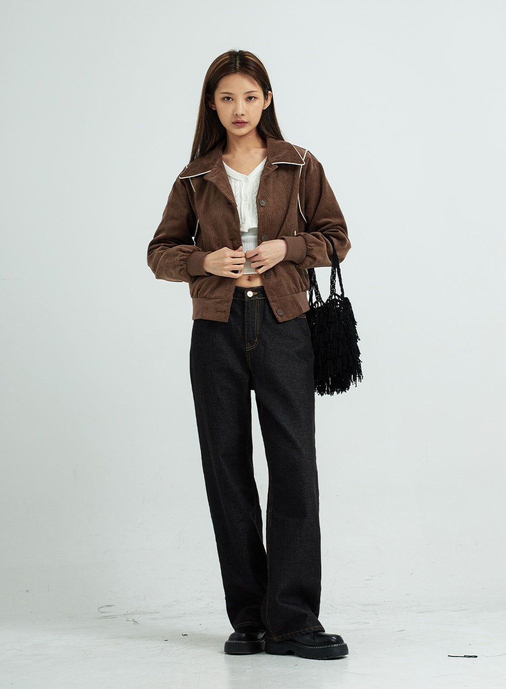 Pepe Wide Pants CS15 in black, full-body front view on model, wide-leg cotton denim, casual outfit with open brown corduroy jacket and black fringe bag.