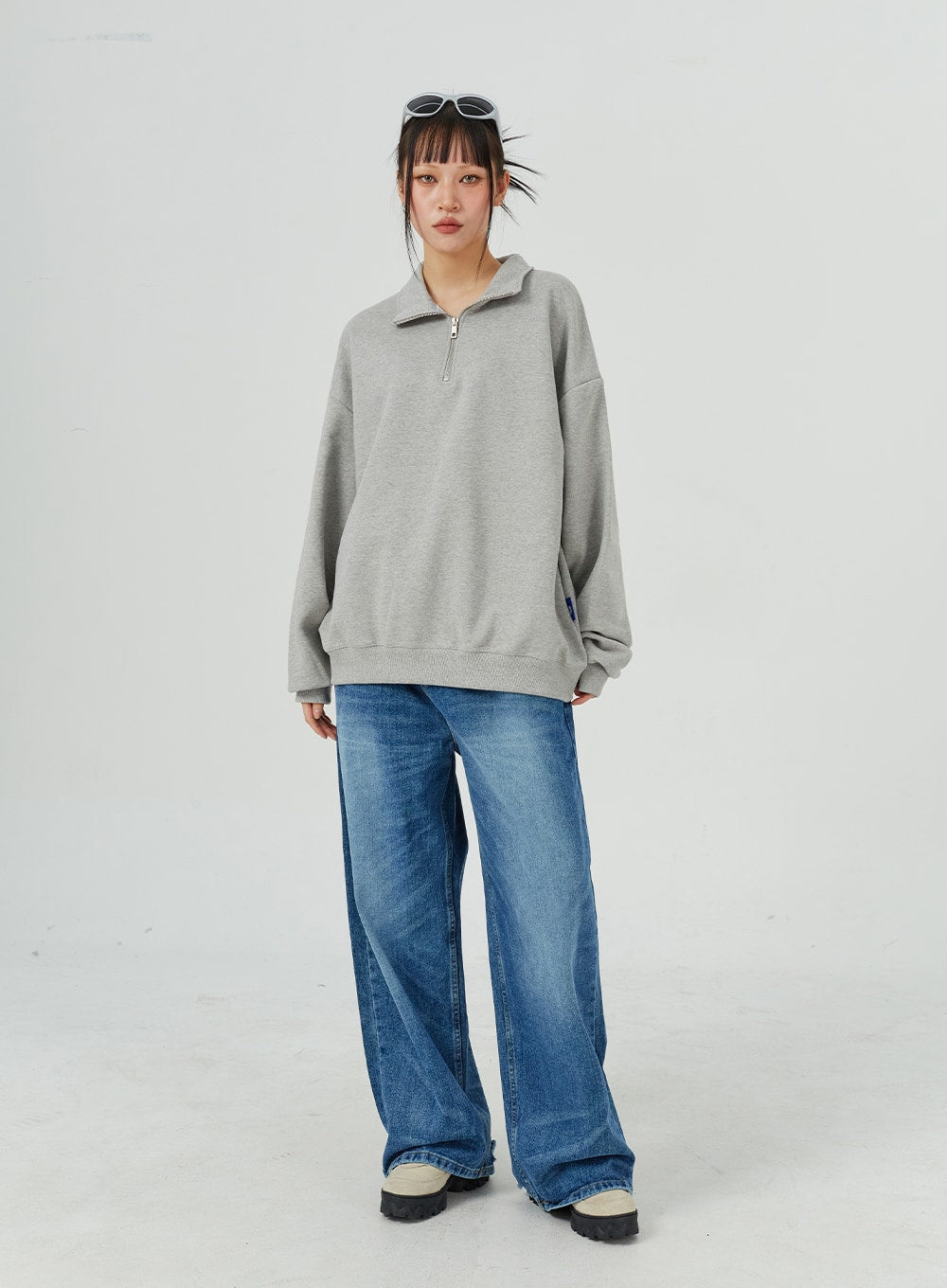 Oversized Jeans Unisex CM321 in blue, full-length front on model with relaxed stance, wide-leg faded denim, paired with oversized grey half-zip sweatshirt.