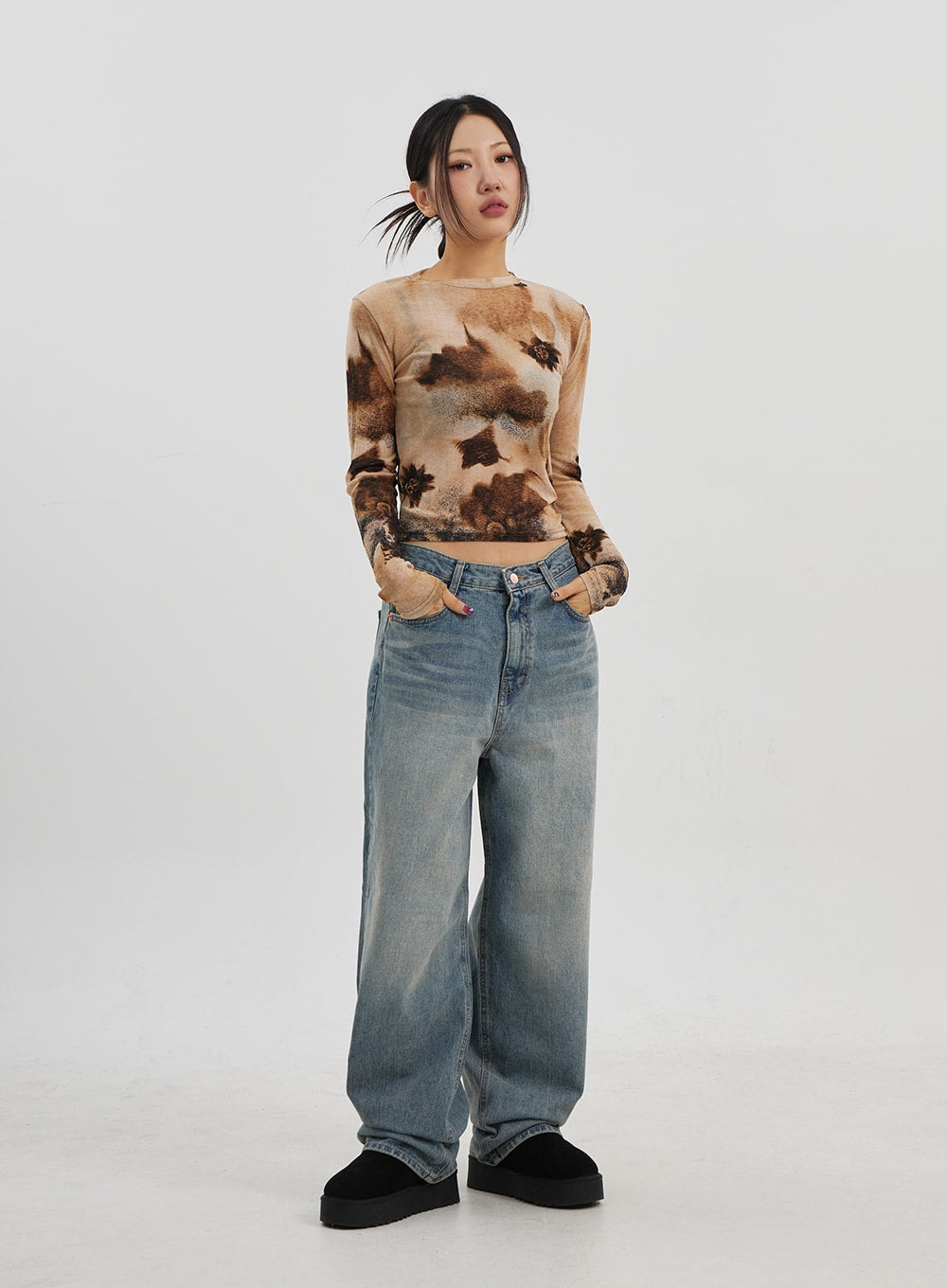 Low Rise Baggy Jeans CJ330 in Blue, full-body front shot on model, hands in pockets, low-waist wide-fit washed denim, paired with brown tie-dye crop top and platform shoes.