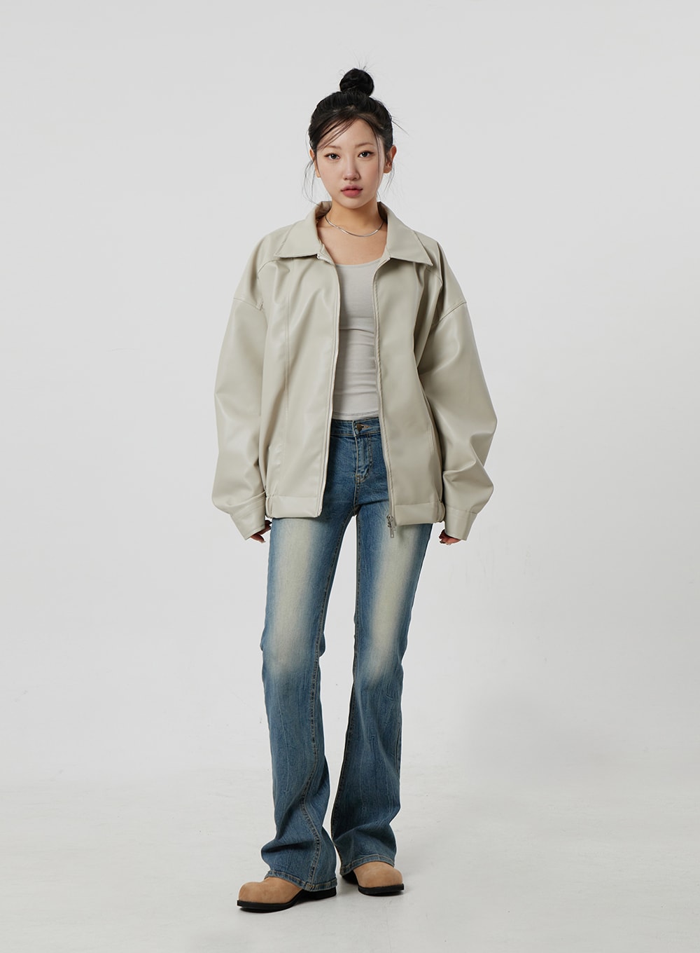 Low Rise Bootcut Jeans CF302 in blue, full-length front shot on model, low-rise slim fit with subtle bootcut hem, vintage wash, layered under open beige jacket and white tank.