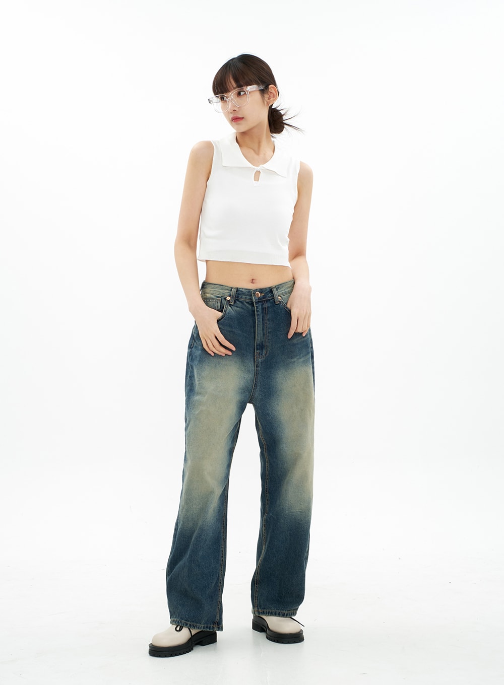 Bleached Wide Leg Denim Pants CA07 in vintage blue, full-body front view on model looking aside, hands in pockets, wide-fit cotton denim with faded gradation, styled with white crop tank.