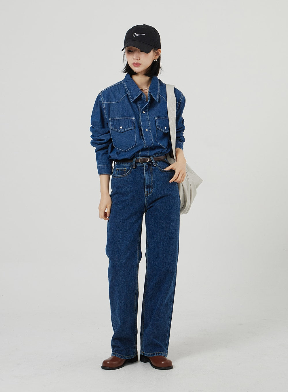 LEWKIN Basic Indigo Jeans OF310 in indigo, full-length front on model, wide-fit cotton denim with high waist and straight leg, paired with denim shirt, brown boots, and cap.