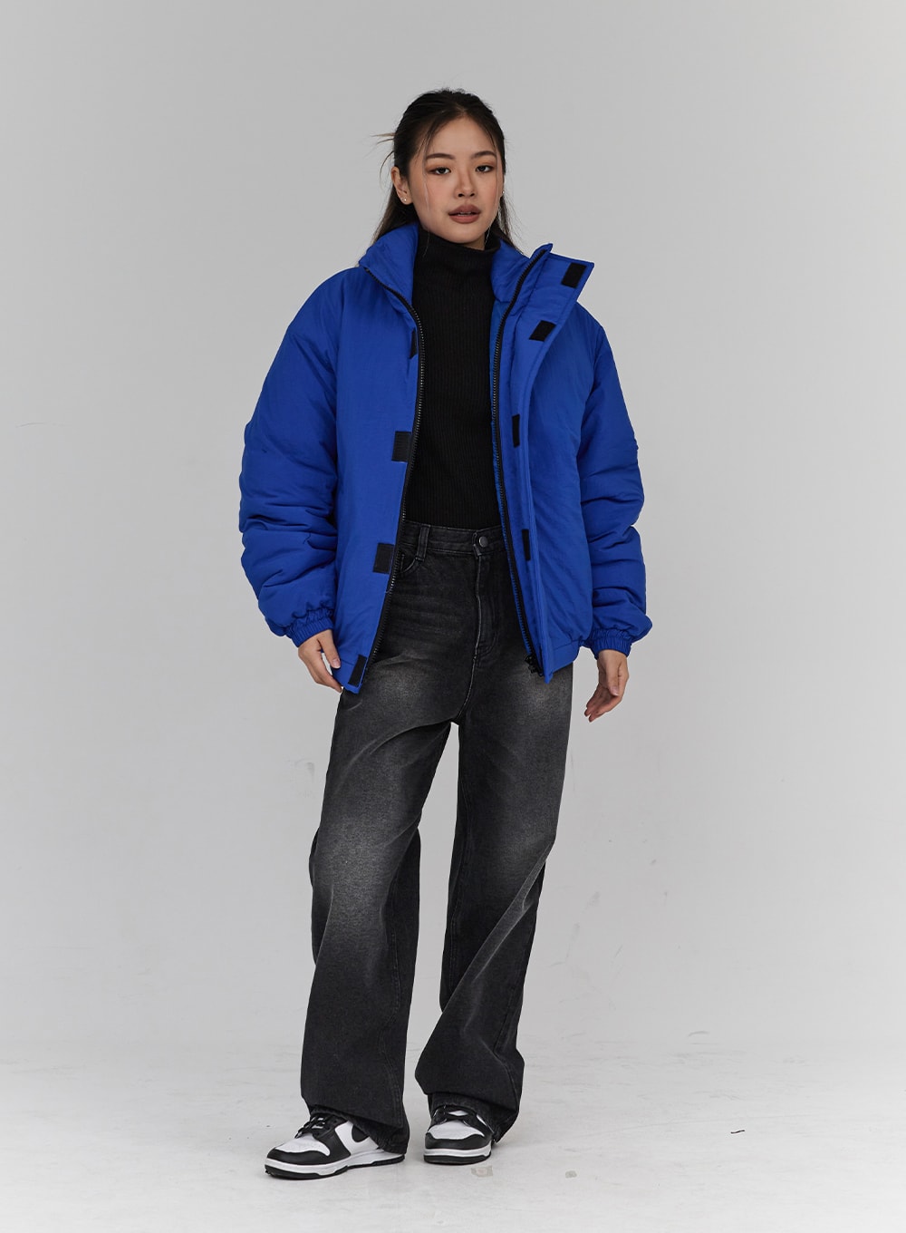 Light Washing Wide Leg Black Jeans CN23 in washed black, full-length slight angle view on model, wide leg cut with faded wash, styled with blue oversized puffer coat and black turtleneck.